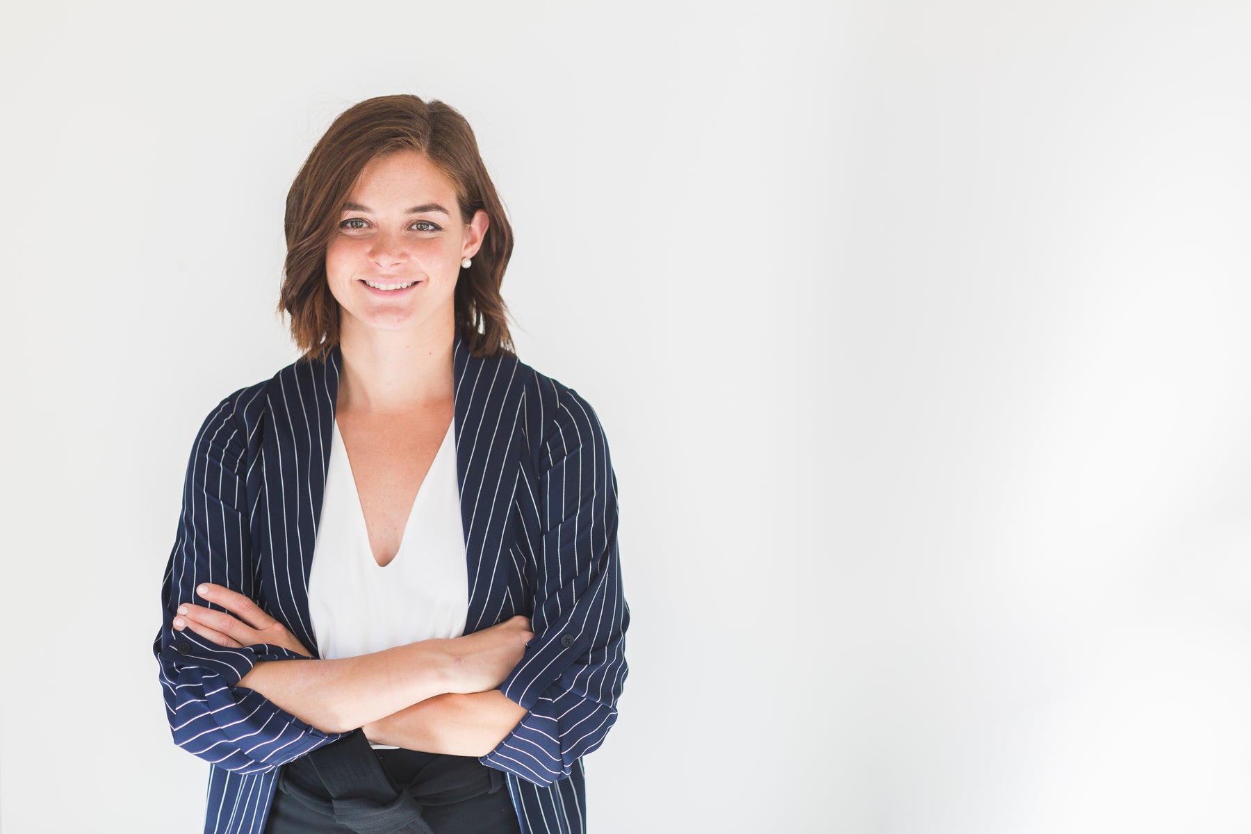 Photo of smiling young woman in business clothes with arms crossed