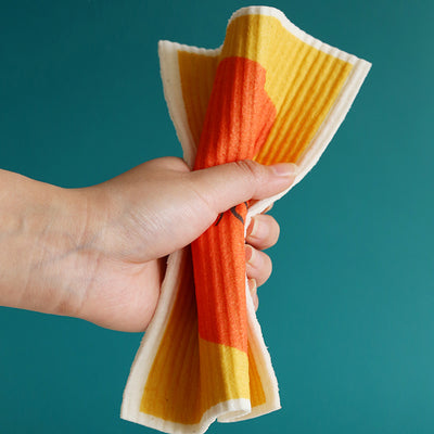 Brightly colored Swedish dish cloth in hand